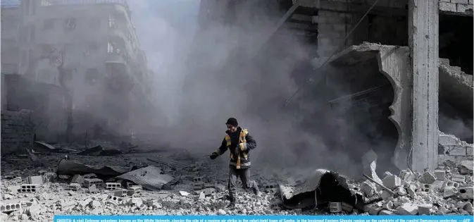 ??  ?? GHOUTA: A civil Defense volunteer, known as the White Helmets, checks the site of a regime air strike in the rebel-held town of Saqba, in the besieged Eastern Ghouta region on the outskirts of the capital Damascus yesterday. —AFP
