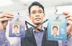  ??  ?? AUTHENTIC PASSES: Election worker M Shukri Baharudin shows passes for internatio­nal observers and liaison officers after Wan Ahmad’s press conference. — Bernama photo