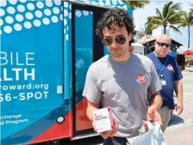  ?? AP PHOTO/FREIDA FRISARO ?? Huston Ochoa, a clinical counselor for The Spot, hands out samples of Narcan, which can reduce opioid overdoses, to spring breakers on Fort Lauderdale Beach, Fla., on March 31. Community activists warned spring breakers of a surge in recreation­al drugs being laced with the dangerous opioid fentanyl, and offered them an antidote for overdoses —which have risen nationally during the COVID-19 pandemic.