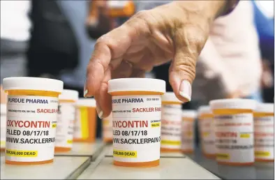  ?? Associated Press file photo ?? Family and friends who lost loved ones to overdoses left pill bottles in protest outside the downtown Stamford headquarte­rs of Purdue Pharma in 2018.