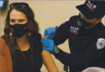  ?? PHOTOS BY JOEL ROSENBAUM — THE REPORTER ?? Andrea Painter-Kamman, Assistant Principal at Vacaville High School receives her first dose of the Pfizer-BioNTech COVID-19 vaccine from Luke Quevedo an EMT with Medic Ambulance Friday at the Solano County Office of Education in Fairfield. Painter-Kamman was one of the one thousand Solano County educators who received their vaccinatio­ns as the county works to get students and teachers back into the classroom.