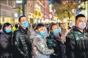  ??  ?? People stand around a giant 3D screen on Jianghan street in Wuhan, China on Sunday.