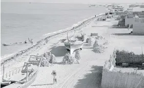  ?? BP Archive ?? Stacks of coral dry on the beach in Abu Dhabi in the mid-20th century. Coral stone was used in the constructi­on of many buildings, including Qasr Al Hosn