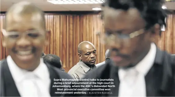  ?? / ALAISTER RUSSELL ?? Supra Mahumapelo (centre) talks to journalist­s during a brief adjournmen­t at the high court in Johannesbu­rg, where the ANC’s disbanded North West provincial executive committee won reinstatem­ent yesterday.