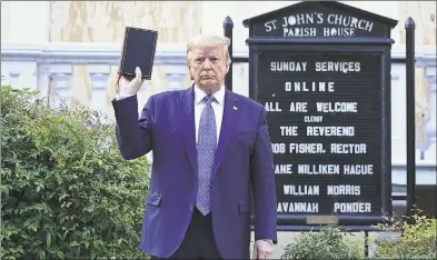  ?? Brendan Smialowski/AFP / TNS ?? President Donald Trump holds up a Bible outside of St John’s Episcopal Church across from Lafayette Park in Washington on Monday.