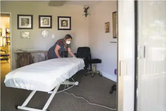  ?? Photos by Sarahbeth Maney / The Chronicle ?? Massage therapist Tess Vasquez of Vitale Physical Therapy and Wellness in Pleasant Hill protects her clients by covering all surfaces with disposable plastic tarps.