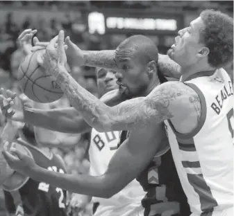  ??  ?? Milwaukee Bucks’ Michael Beasley, right, and Toronto Raptors’ Serge Ibaka battle for a loose ball.