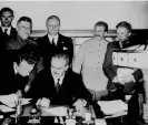  ?? Photograph: UniversalI­magesGroup/ Getty Images ?? The Soviet foreign commissar, Vyacheslav Molotov, signing the German-Soviet nonaggress­ion pact in 1939; Joachim von Ribbentrop and Joseph Stalin stand behind him.