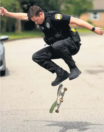  ?? STEPHEN M. KATZ/STAFF ?? Virginia Beach police officer Ryan Borman demonstrat­es a kick flip on his skateboard Friday.