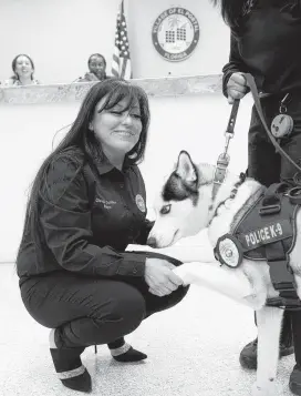  ?? ROBERTO KOLTUN rkoltun@miamiheral­d.com ?? El Portal Mayor Claudia V. Cubillos, left, shakes Arctic’s paw during a ceremony in which the Siberian husky was officially sworn in as a K-9 officer.