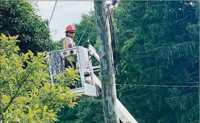  ?? Luther Turmelle / Hearst Connecticu­t Media ?? An unidentifi­ed utility lineman installs fiber optic cable on a utility pole in Cheshire on July 29.