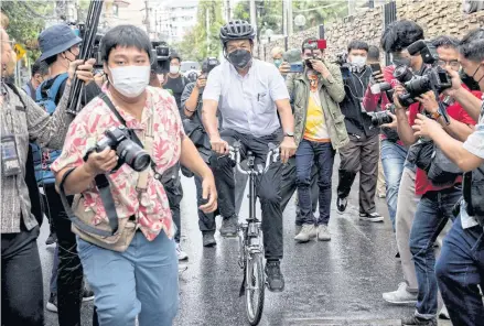  ?? AFP ?? Chadchart Sittipunt rides a bike after casting his vote in the governor elections in Bangkok on Sunday.