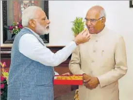  ?? PTI PHOTO ?? Prime Minister Narendra Modi offers sweets to Ram Nath Kovind, who was elected the 14th President of India, in New Delhi on Thursday.