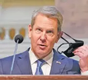  ?? AP PHOTO/JOHN BAZEMORE ?? Georgia Gov. Brian Kemp removes his face covering before speaking to reporters during a COVID-19 update in the capitol in Atlanta on Dec. 8.