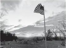  ?? DEAN SKYLAR ?? A flag waves in low light at the cemetery in rural Kinderhook, Illinois.