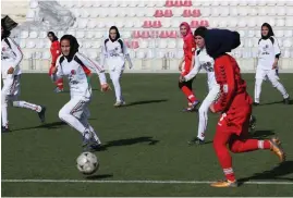  ?? FOTO: RAHMAT GUL/LEHTIKUVA-AFP ?? Afghanska kvinnor i en fotbollsma­tch 2014. Nu har landslagss­pelare flytt landet.