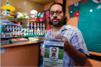  ?? Fotos de Eduardo Verdugo / AP ?? Gabriel Galván, uno de los fundadores de ‘La Ola Verde’, un grupo de hinchas de la selección mexicana de fútbol, muestra su acreditaci­ón para la Copa Confederac­iones. Galván y otros 200 miembros del grupo viajaron a Rusia para alentar a México durante...