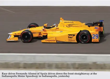  ??  ?? Race driver Fernando Alonso of Spain drives down the front straightaw­ay at the Indianapol­is Motor Speedway in Indianapol­is, yesterday