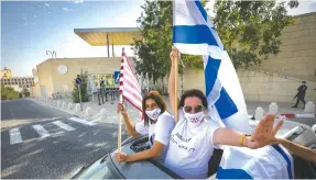  ?? ( Olivier Fitoussi/ Flash90) ?? TRUMP SUPPORTERS wave US and Israeli flags in support of the president’s candidacy outside the US Embassy in Jerusalem yesterday.