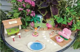  ??  ?? Julie Cole's love of fairy gardens has grown into a series of themed classes, including a hanging basket workshop Tonia Varcette and her mom, Joyce Brown, joined.