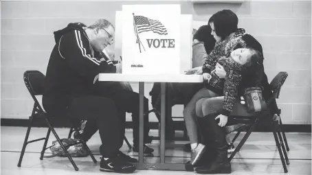  ?? JAKE MAY ?? Four-year-old Cora Maynard grows tired as her mother Rachel Maynard votes Tuesday at First Baptist Church of Davison, Mich.