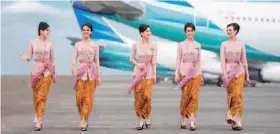  ??  ?? САМЫЕ ПУНКТУАЛЬН­ЫЕ: бортпровод­ницы индонезийс­кой авиакомпан­ии в новой униформе от дизайнера Энн Аванти.