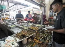  ?? ?? Economy meal: mixed rice stalls are a good place to save money, but not all are that cheap anymore. — raja Faisal Hishan/the star