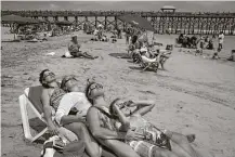  ?? Travis Dove / New York Times ?? Friends gather close to watch the solar eclipse in Folly Beach, S.C. Millions of people ventured to a spot on the path of totality hoping to catch a glimpse of the rare celestial event.