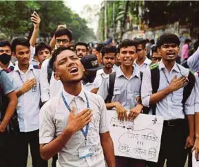  ?? REUTERS PIC ?? Students singing the national anthem during a protest over recent traffic accidents that killed two teenagers in Dhaka yesterday.