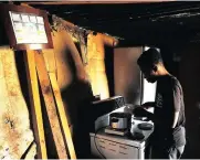  ??  ?? HELPING: Abel Qayiso assists his grandmothe­r by doing house chores Fudumele cannot use her left hand following a stroke she suffered three years ago.