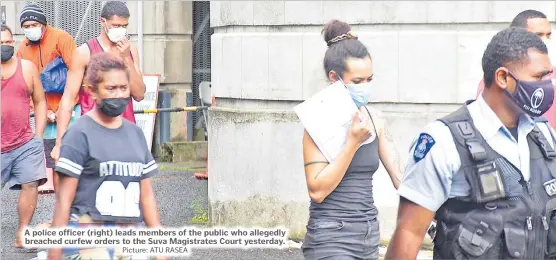  ?? Picture: ATU RASEA ?? A police officer (right) leads members of the public who allegedly breached curfew orders to the Suva Magistrate­s Court yesterday.