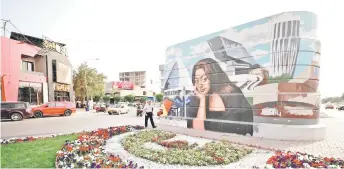  ?? ?? A mural drawn by Majed of Iraqi architect Zaha Hadid, drawn by Majed, on a concrete structure in Baghdad.