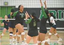  ?? BRIAN KRISTA/BALTIMORE SUN MEDIA ?? Arundel’s Kennedy McDowney (19) celebrates with teammates after winning a point Tuesday during an eventual five-set win over Reservoir at Arundel.