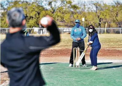  ?? Photos by Robin Jerstad / Contributo­r ?? Teresa Menendez Myers, chief of staff for Councilwom­an Shirley Gonzales, bats as Mayor Ron Nirenberg throws during the San Antonio Premier Cricket League inaugurati­on of the Monterrey Park Cricket Grounds on Sunday afternoon.