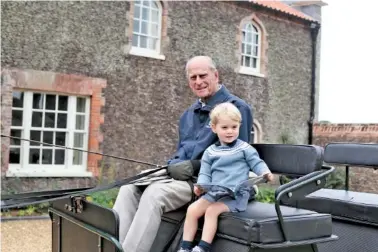  ?? DUKE AND DUCHESS OF CAMBRIDGE VIA AP ?? In this undated handout photo, Britain’s Prince Philip sits with his great-grandson Prince George in England.