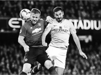  ?? DAVE THOMPSON
THE ASSOCIATED PRESS ?? Manchester United’s Luke Shaw, left, and Manchester City’s Ilkay Gundogan challenge for the ball during the English Premier League soccer match between the crosstown rivals Sunday at the Etihad stadium.