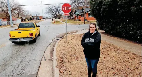  ?? [PHOTOS BY STEVE SISNEY, THE OKLAHOMAN] ?? Amanda Green and her husband have been stopped three times recently by Oklahoma City police, accused of rolling through a stop sign at NW 30 and McKinley. She says a hedge makes it difficult for drivers to see oncoming traffic.