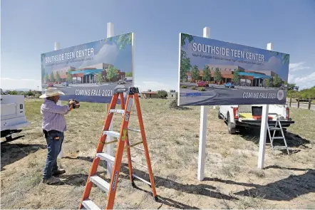  ?? LUIS SÁNCHEZ SATURNO/THE NEW MEXICAN ?? Fernando Piña, with the city of Santa Fe Public Works Department, put up signs for the future Southside Teen Center Tuesday at the location of the new facility on Valentine Way. The project is expected to be completed in 18 months.