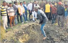  ?? PTI ?? A villager digs a grave to bury the bodies of the two minor Dalit girls, who were found dead in a field at Baburaha village in Unnao district, on Friday.