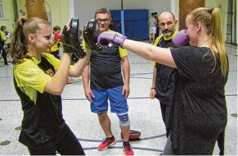  ?? Fotos (2): Dirk Sing ?? Haben beim Boxclub Neuburg alles im Blick und Griff: Die beiden Trainer Adam Klakus (hinten links) und Klaus Schmidt (hinten rechts). Auch die weiblichen Boxsport Inte ressierten kommen in der Städtische­n Turnhalle voll auf ihre Kosten.