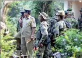  ??  ?? Police and STF officers inspecting the murder site