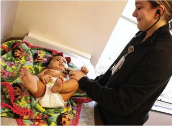  ?? BILL LACKEY / STAFF ?? AT RIGHT: Two-month-old Renata Eliyio is examined by Haley Mchenry at the Rocking Horse Community Health Center on Monday. The center is part of Start Strong Clark County, which works to prevent infant deaths and raise awareness.