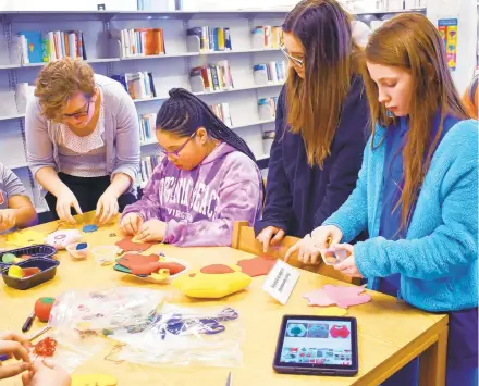  ?? COURTESY OF AACPL ?? Teens work on crafts at the Edgewater Library.