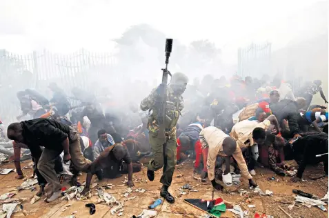  ??  ?? Police fired tear gas into crowds trying to force their way into the Kasarani Stadium in Nairobi to watch the inaugurati­on of Uhuru Kenyatta as president of Kenya