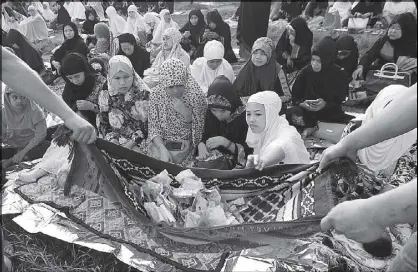  ?? EDD GUMBAN ?? Muslims collect money donations for victims of the Marawi conflict during the celebratio­n of Eid’l Fitr at the Quirino Grandstand in Manila yesterday.