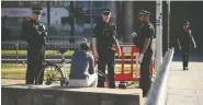  ?? OLI SCARFF / AFP VIA GETTY IMAGES ?? Police speak to a man sitting down in Manchester as Britain remains under lockdown due to COVID-19.