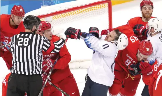  ?? | GETTY IMAGES ?? Garrett Roe gets into a scrap with Russia’s Bogdan Kiselevich on Saturday. With the loss, the U. S. must play in the qualificat­ion round Tuesday to reach the medal round.