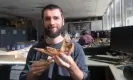  ?? Photograph: Flinders University ?? Palaeontol­ogist Isaac Kerr holds the fossil jaw of the extinct giant Protemnodo­n viator, alongside the smaller jaw of a red kangaroo.