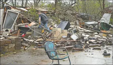  ?? NWA Democrat-Gazette/ANDY SHUPE ?? Matt Kimes of West Fork sorts through the rubble Friday of a detached garage and home owned by his grandmothe­r, Farnese Kimes, in downtown Mountainbu­rg after a tornado swept through the Crawford County town.