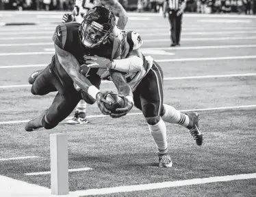  ?? Brett Coomer / Houston Chronicle ?? El quarterbac­k de los Texans, Deshaun Watson (izq.), anota un touchdown contra los Patriots de Nueva Inglaterra en el juego de la NFL disputado el domingo 1 de diciembre en el NRG Stadium de Houston.